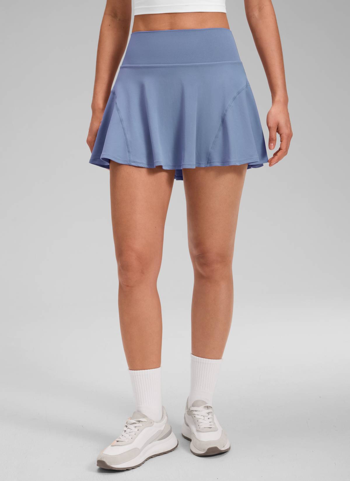 CRZ YOGA Women's Softretch Tennis High Rise Pocket Flowy Pleated Skirt Washed Denim @model_info:Larissa